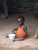 Ewe village boy eats lunch